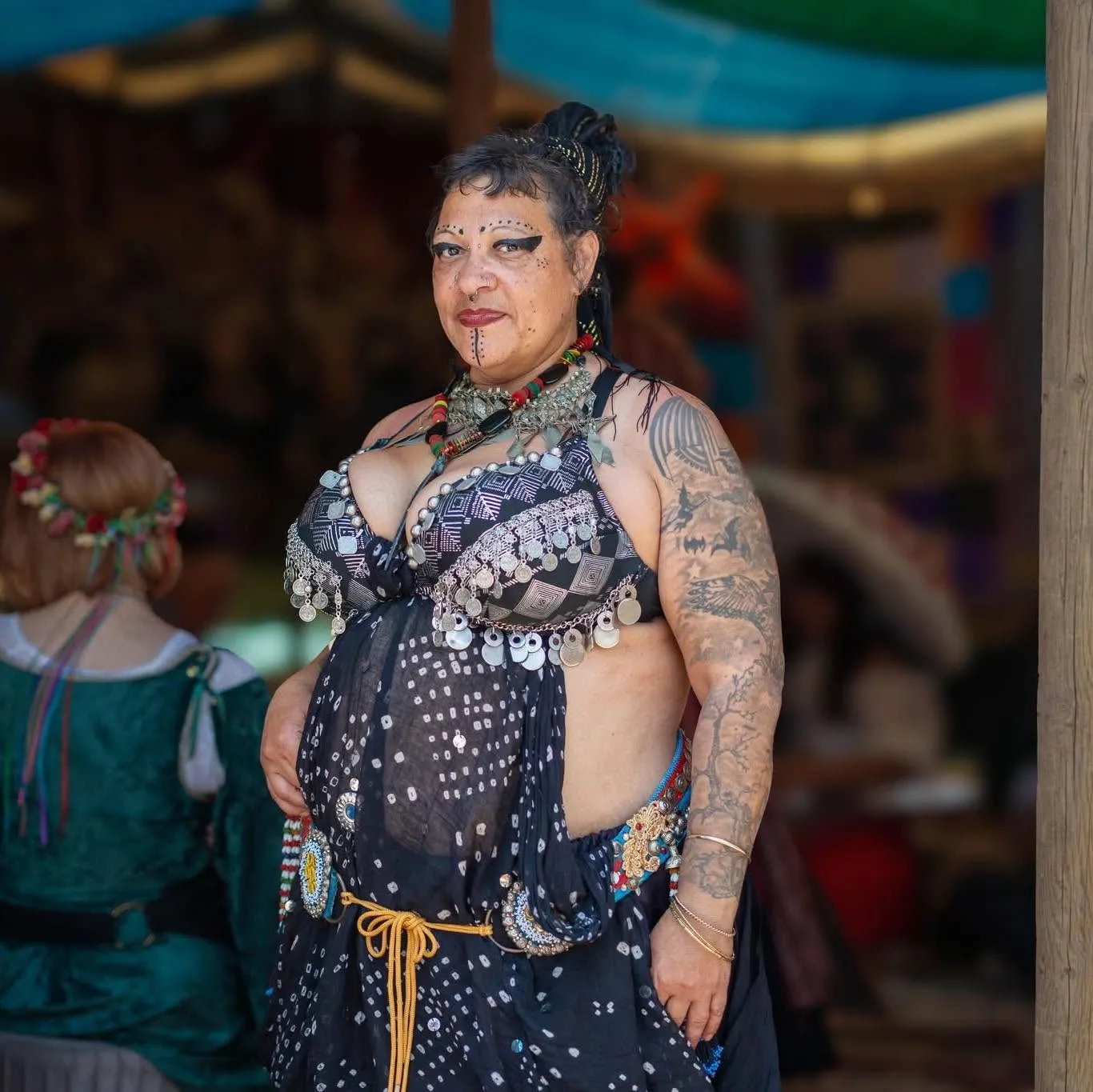Marjhani in tribal belly dance costume, coin bra, face markings and tattoos at a Renaissance faire